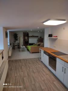 cocina y sala de estar con sofá en el fondo en Leipzig-Neuseeland-Ferienwohnung, en Rötha