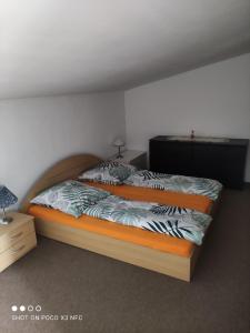 een slaapkamer met een bed en een dressoir en een nachtkastje bij Leipzig-Neuseeland-Ferienwohnung in Rötha