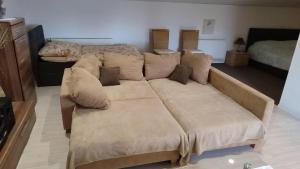 a brown couch in a living room with a bed at Leipzig-Neuseeland-Ferienwohnung in Rötha