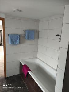 een badkamer met een bad en 2 blauwe handdoeken bij Leipzig-Neuseeland-Ferienwohnung in Rötha