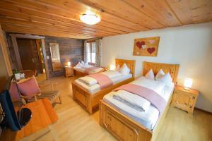 a bedroom with two beds and a chair in it at Chalet Sonne Vandans in Vandans