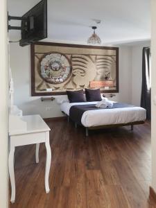 a bedroom with two beds and a tv on the wall at El Indio CHocolatería Boutique Hostel in Pinto