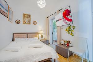 a bedroom with a large white bed and a window at Jelena Apartments By The Sea in Agios Nikolaos