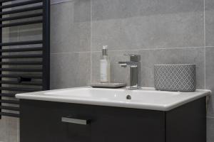 a bathroom sink with a soap bottle on it at Modern George Street Studio sleeping 2 in Edinburgh
