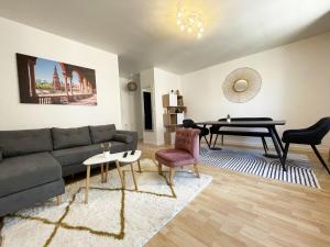a living room with a couch and a table at Au bord de l'Eure - Free parking in Chartres