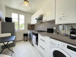 a kitchen with white cabinets and a washer and dryer at Au bord de l'Eure - Free parking in Chartres