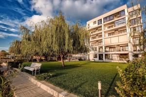 un edificio de apartamentos con un árbol y un parque en Apartment Summer Lamera, en Mamaia