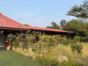 una casa con un jardín delante de ella en The Green Wood Palace I Farm House I wedding I Party I 87oo2o5865, en Gurgaon