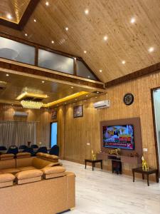 a lobby with couches and a flat screen tv at The Green Wood Palace I Farm House I wedding I Party I 87oo2o5865 in Gurgaon