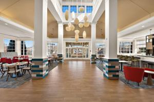 a lobby with tables and chairs in a building at Hilton Garden Inn Williamsburg in Williamsburg