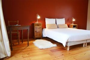 ein Schlafzimmer mit einem Bett und einem Tisch mit einer Lampe in der Unterkunft Le Convivial - Paisible propriété proche ParisChartres in Réclainville