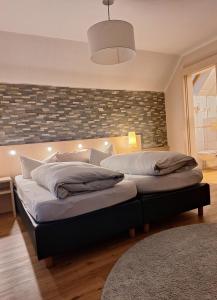 two beds in a bedroom with a wall at Hotel Garni Pension Zur Krone in Hilpoltstein