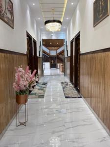 a hallway of a hotel with a vase of flowers at The Green Wood Palace I Farm House I wedding I Party I 87oo2o5865 in Gurgaon