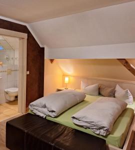a bed with two pillows on it in a bedroom at Hotel Garni Pension Zur Krone in Hilpoltstein