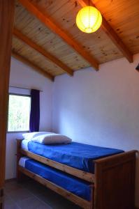 a bedroom with a bed with a light on the ceiling at Cabañas Las Violetas Patagonia in El Bolsón