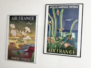 dos carteles en la pared de una galería de arte en L'aviateur - self check in, en Chartres