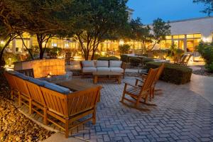 eine Terrasse mit Stühlen und eine Feuerstelle mit einem Sofa in der Unterkunft Hilton San Antonio Hill Country in San Antonio