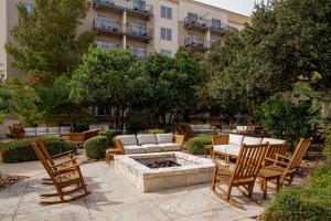 a patio with chairs and a fire pit in front of a building at Hilton San Antonio Hill Country in San Antonio