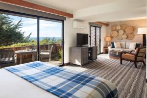 Schlafzimmer mit einem Bett und einem Balkon mit einem TV in der Unterkunft Hyatt Vacation Club At Highlands Inn in Carmel