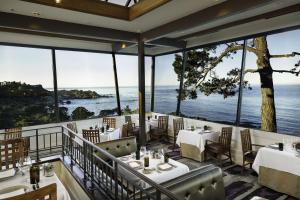 a restaurant with tables and chairs and a view of the ocean at Hyatt Vacation Club At Highlands Inn in Carmel