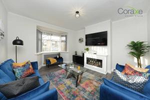 a living room with blue couches and a fireplace at 3 Bedroom Tranquil Haven for Contractors and Families by Coraxe Short Stays in Old Hill