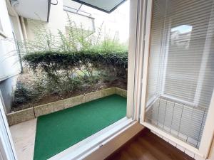 Una habitación con una ventana con suelo verde. en L'Estival - Free parking, en Mainvilliers