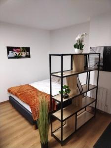 a room with a bed and a shelf with plants at L'Estival - Free parking in Mainvilliers