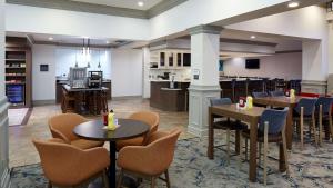 a restaurant with tables and chairs and a kitchen at Hilton Garden Inn Merrillville in Merrillville