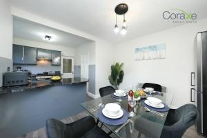 a dining room and kitchen with a glass table and chairs at 3 Bedroom Tranquil Haven for Contractors and Families by Coraxe Short Stays in Old Hill