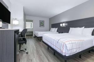 a hotel room with two beds and a flat screen tv at La Quinta Inn by Wyndham Dallas Uptown in Dallas