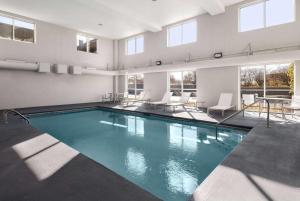 艾科亞的住宿－諾克斯維爾機場拉金塔旅館及套房，一座带桌椅的游泳池