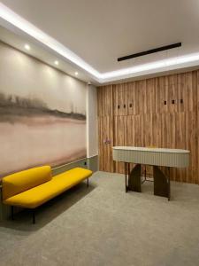 un banco amarillo y una mesa en una habitación en Bubu - Nuevo edificio de apartamentos en el centro, en Málaga