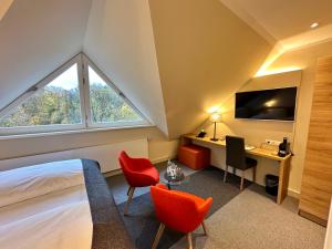 Schlafzimmer mit einem Bett, einem Schreibtisch und einem Fenster in der Unterkunft Hotel Stempferhof in Gößweinstein
