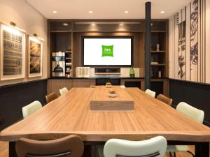 a conference room with a large wooden table and a television at Ibis Styles Hotel Paris Gare de Lyon Bastille in Paris