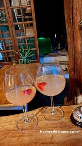 ProyectoQva Glamping في Villa Ballester: كأسين من النبيذ يجلسون على طاولة خشبية