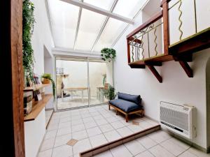 un soggiorno con lucernario e sedia di NOUVEAU - Maison Cozy 150m2 - 3 chambres - Grand Salon - Clim - Wifi fibre - Netflix - 5' du centre et gare - Cour intérieure - 15' des plages a Montpellier