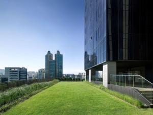 trawiaste pole obok budynku z wysokimi budynkami w obiekcie Sofitel Ambassador Seoul Hotel & Serviced Residences w Seulu