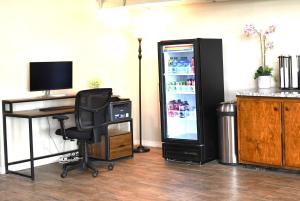 ein Büro mit einem Schreibtisch, einem Computer und einem Kühlschrank in der Unterkunft Travelodge by Wyndham Trinidad in Trinidad