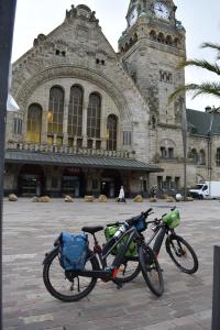 ein Fahrrad, das vor einem Gebäude mit einem Uhrturm geparkt ist in der Unterkunft Chambre d'Hôtes Plesnois 