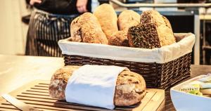 a basket of loaves of bread on a table at Hjorten Hotell Hitra in Fillan