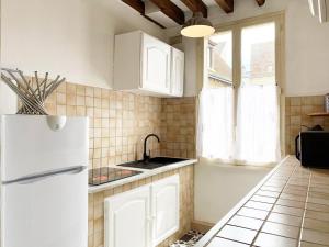 a kitchen with a white refrigerator and a window at Le Clocher- Appartement dans le cœur de ville in Chartres