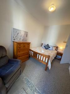1 dormitorio con 1 cama, vestidor y sofá en Home in Church corner, en Christchurch
