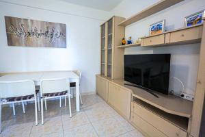 a dining room with a table and a tv at Mar Azul Litoral - COSTA DORADA in Cambrils