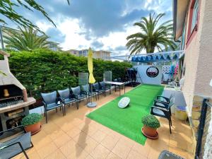 a patio with chairs and a green lawn at Escuela de Surf Waves Sound in Santoña