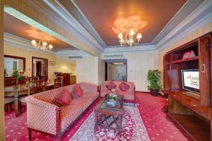 a living room with two couches and a television at Ascot Hotel in Dubai