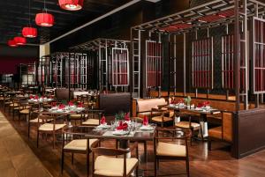 una sala da pranzo con tavoli, sedie e luci rosse di Wyndham Grand Phu Quoc a Phu Quoc