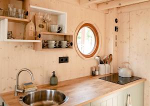a kitchen with a sink and a counter top at Tiny-Hausboot mit Kamin und Dachterrassenlounge in Hamburg