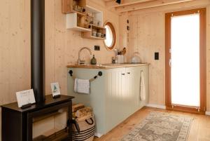 a kitchen with a sink and a stove in a room at Tiny-Hausboot mit Kamin und Dachterrassenlounge in Hamburg