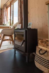 a television in a living room with a chair at Tiny-Hausboot mit Kamin und Dachterrassenlounge in Hamburg