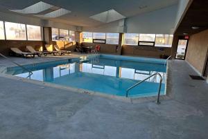 a large swimming pool with blue water in a building at AmericInn by Wyndham Woodstock IL in Woodstock